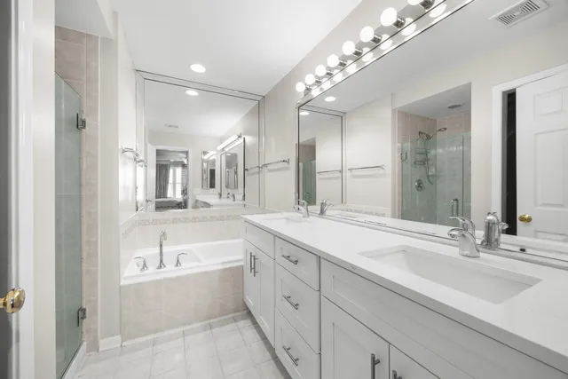 a spacious en suite bathroom with a large tub sink and mirror