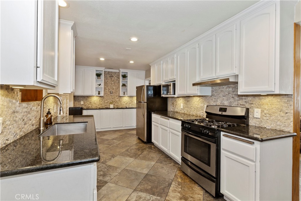1705 Jeryl Avenue Colton, CA 92324 - Photo 7 of 24 a kitchen with granite countertop a stove sink and cabinets