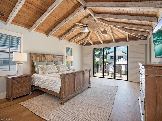 a bedroom with a bed a dresser next to a window