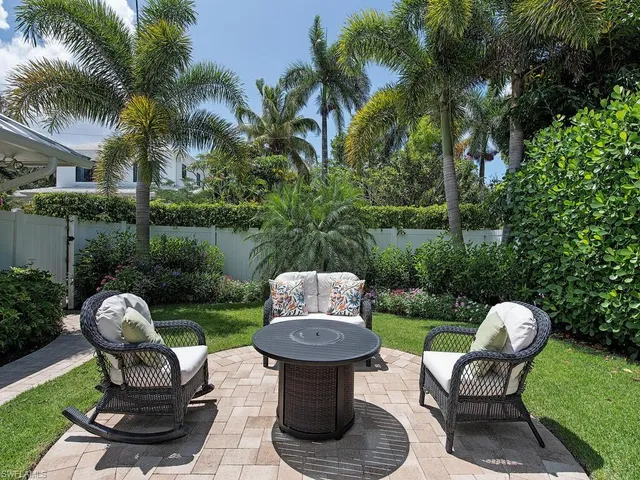 a view of a chair and table in backyard of a house