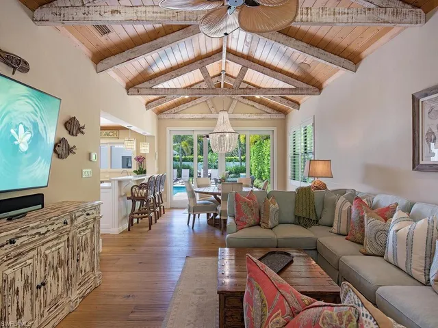 a living room with furniture a flat screen tv and a floor to ceiling window