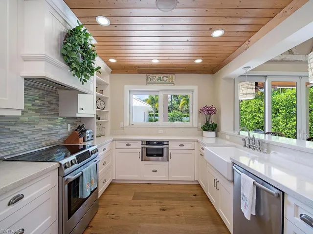 a kitchen with a stove a sink and a window
