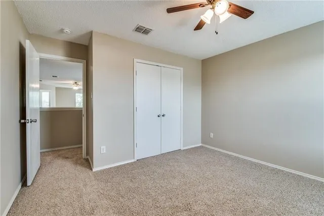 a view of an empty room with a chandelier fan
