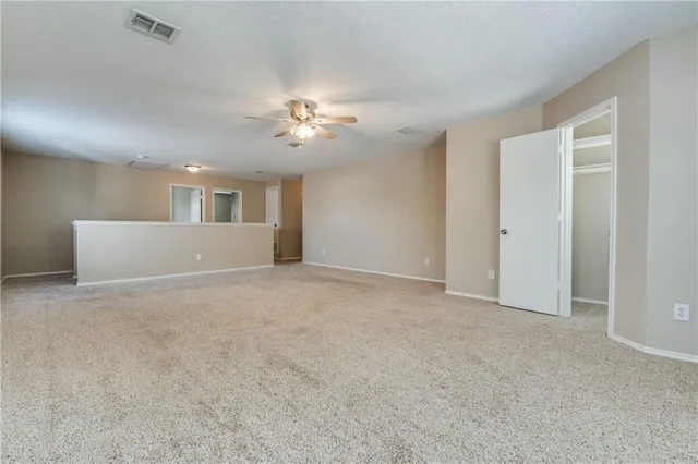 a view of empty room with a chandelier fan and windows