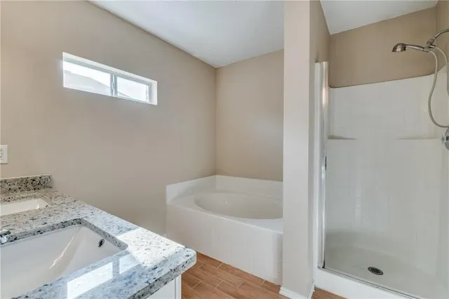 a bathroom with a granite countertop sink and a bathtub