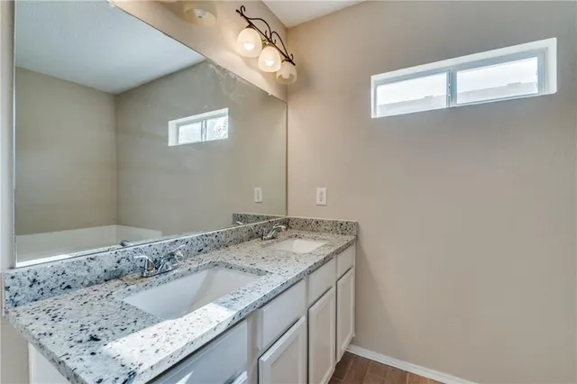 a bathroom with a granite countertop sink and a mirror