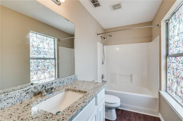 a bathroom with a granite countertop sink toilet and shower