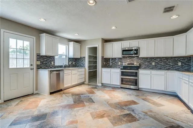 a kitchen with granite countertop a stove sink microwave and cabinets