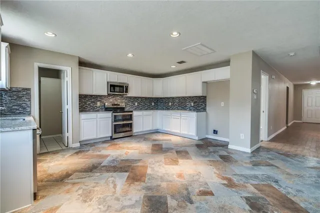 a large kitchen with cabinets and stainless steel appliances
