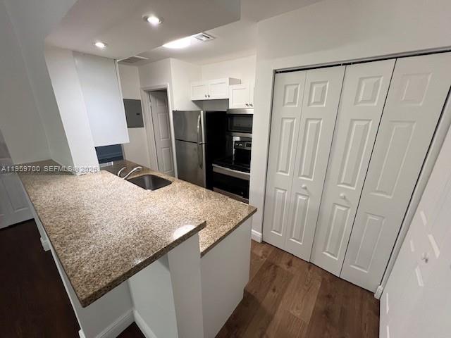 a kitchen with stainless steel appliances granite countertop refrigerator sink and microwave