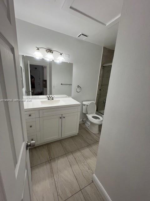 18336 Northwest 68th Avenue, Unit E Hialeah, FL 33015 - Photo 4 of 9 a bathroom with a sink a toilet and mirror