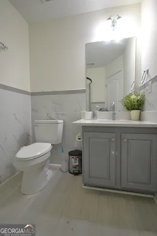 a bathroom with a toilet a sink and mirror