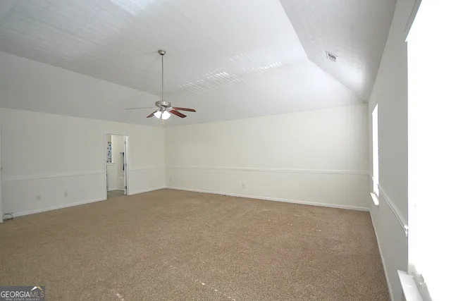 an empty room with a ceiling fan and a window