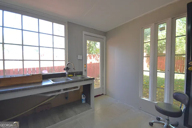 a view of a workspace with furniture and a window