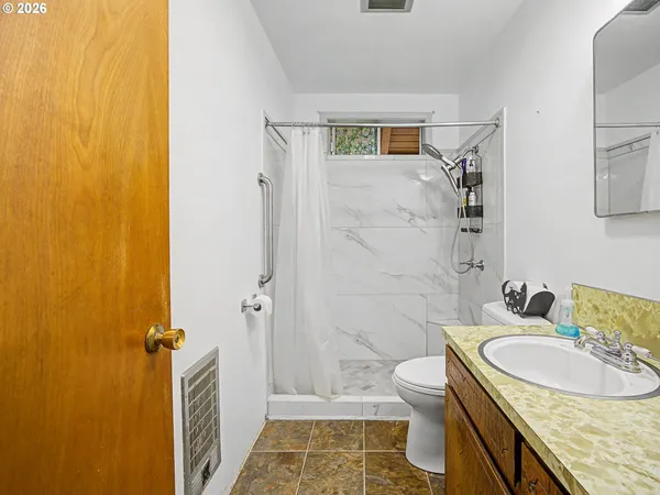 a bathroom with a granite countertop sink toilet and shower