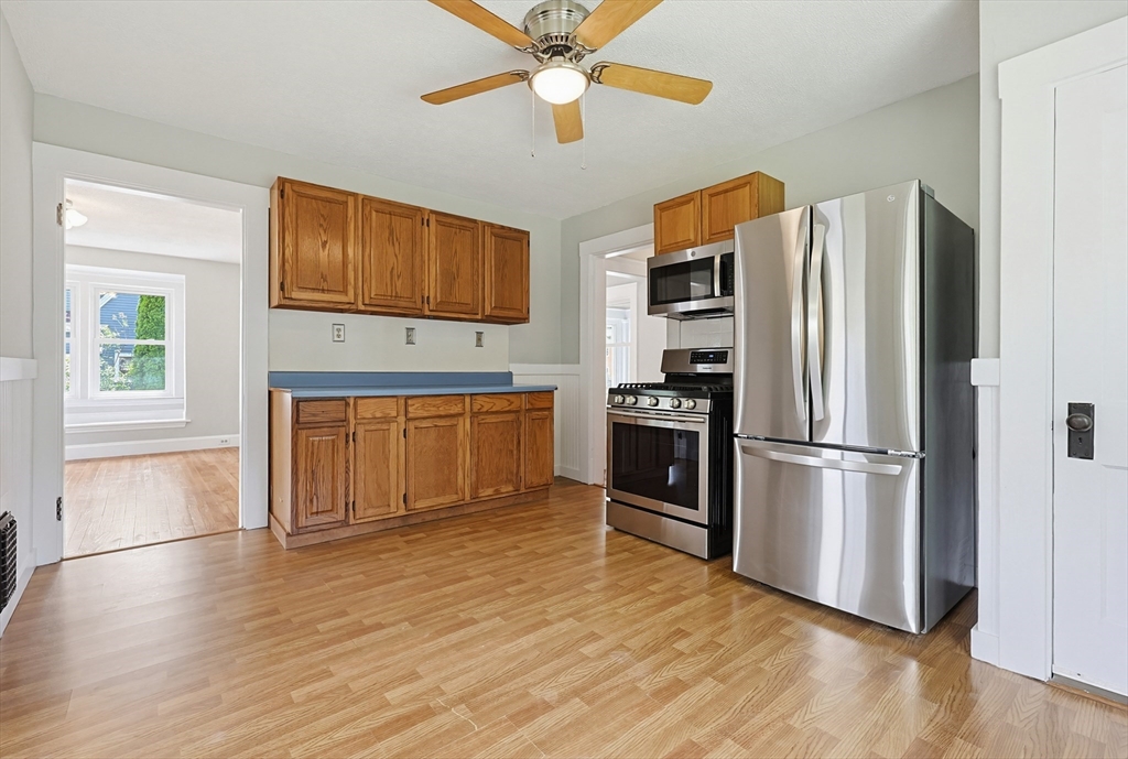10 Water Street Natick, MA 01760 - Photo 10 of 35 a kitchen with granite countertop a refrigerator a stove a microwave oven cabinets and wooden floor