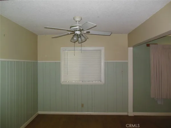a view of a small space with wooden floor and fan