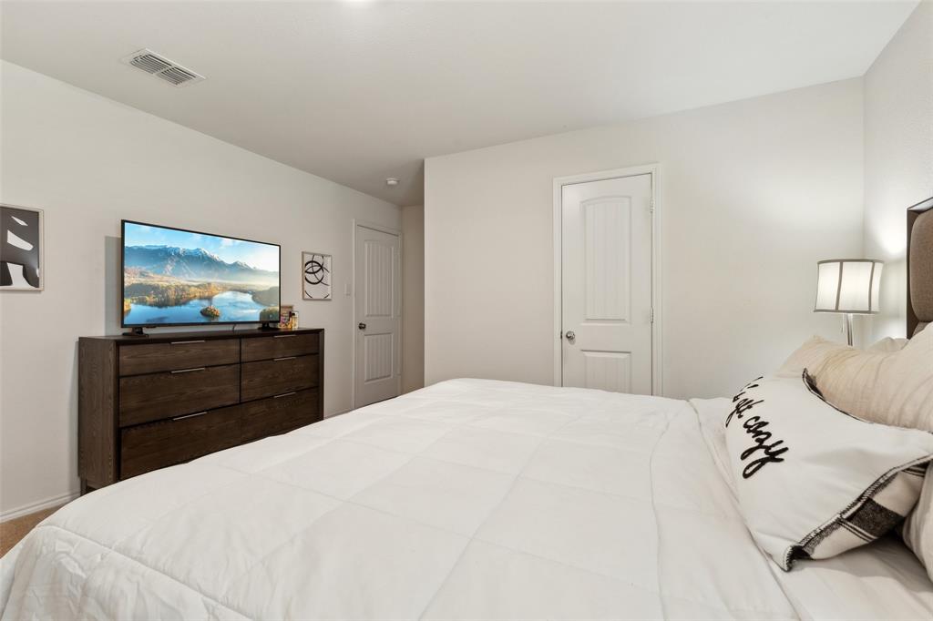 425 Sweetshade Lane Princeton, TX 75407 - Photo 15 of 29 a bedroom with a bed and a flat screen tv
