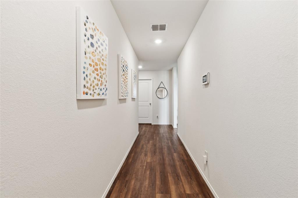 425 Sweetshade Lane Princeton, TX 75407 - Photo 2 of 29 a view of a hallway with wooden floor and a bathroom