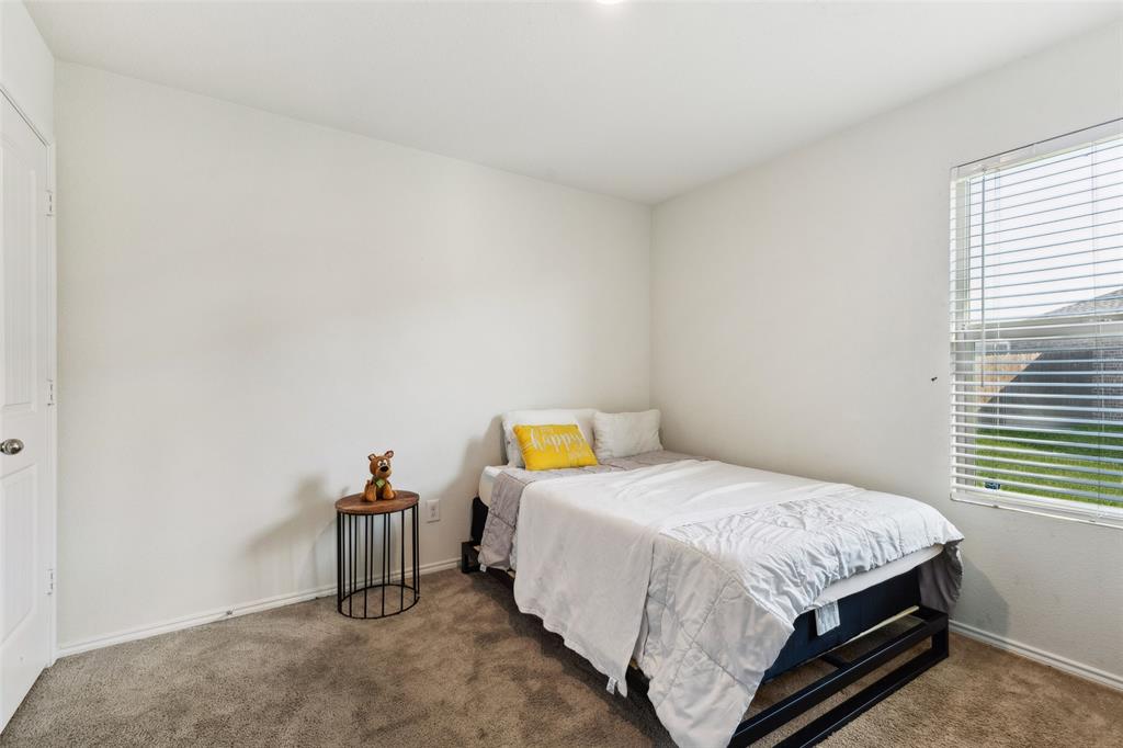 425 Sweetshade Lane Princeton, TX 75407 - Photo 4 of 29 a bed sitting in a bedroom next to a window