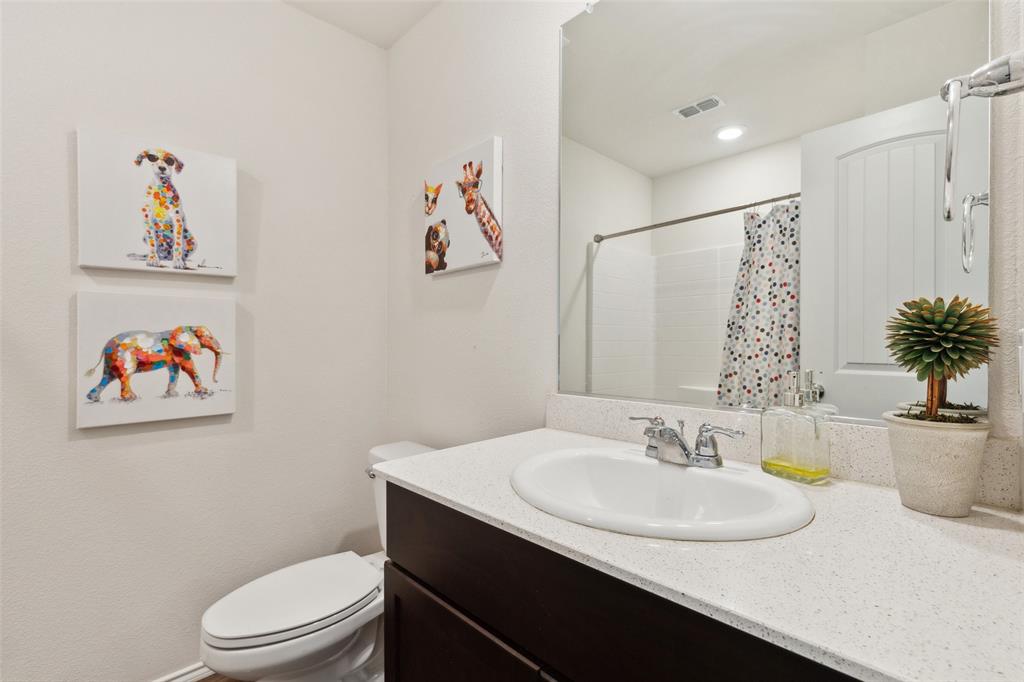 425 Sweetshade Lane Princeton, TX 75407 - Photo 5 of 29 a bathroom with a sink toilet and a mirror
