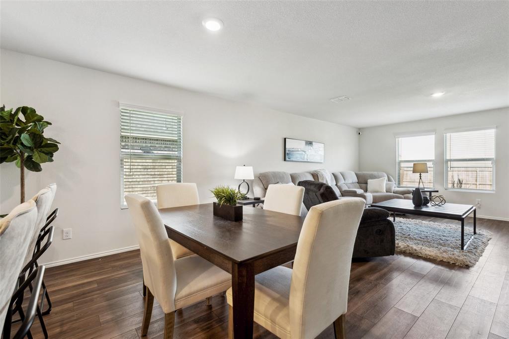 425 Sweetshade Lane Princeton, TX 75407 - Photo 9 of 29 a view of a dining room and livingroom with furniture wooden floor and a rug