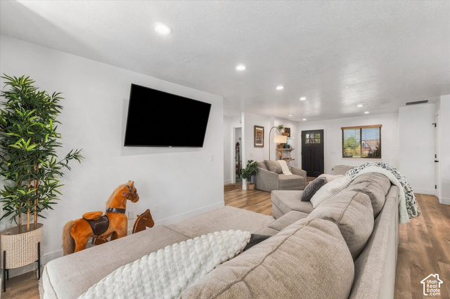437 Scenic Heights Road Kamas, UT 84036 - Photo 9 of 46 Open-concept living area featuring recessed lighting, wood-finish flooring, and a mounted display area