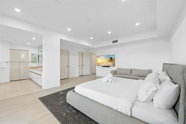 a bedroom with a bed and a view of kitchen