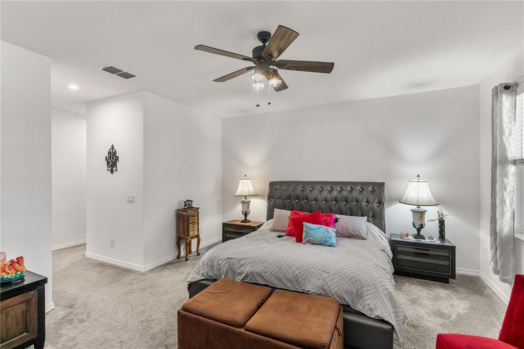 5637 Beggs Road St. Cloud, FL 34771 - Photo 18 of 35 a bedroom with a bed and a lamp on the dresser