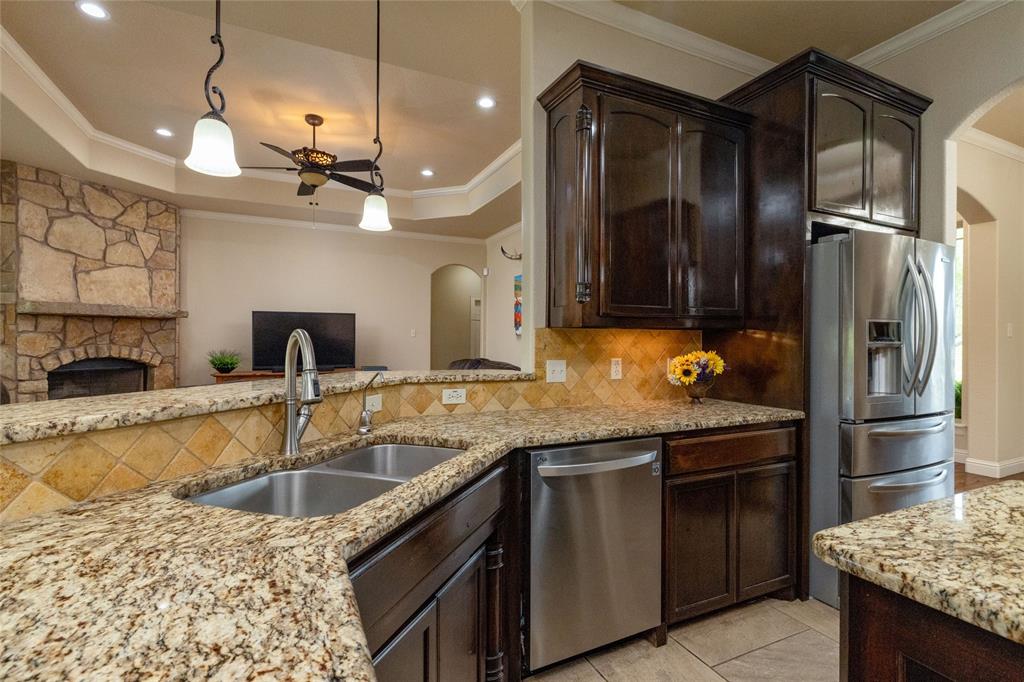 208 Ellis Creek Drive Weatherford, TX 76085 - Photo 40 of 40 a kitchen with granite countertop stainless steel appliances and wooden cabinets