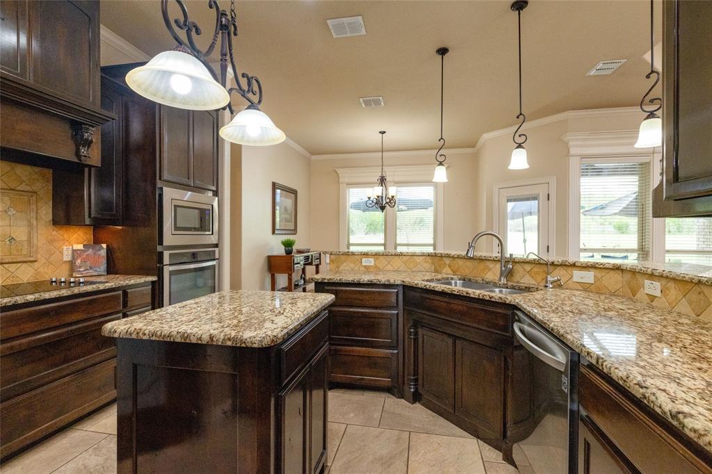 208 Ellis Creek Drive Weatherford, TX 76085 - Photo 20 of 40 a kitchen with granite countertop a sink a counter space appliances and cabinets