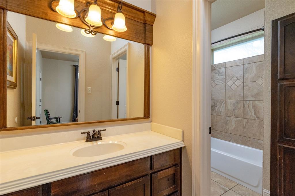 208 Ellis Creek Drive Weatherford, TX 76085 - Photo 28 of 40 a bathroom with a granite countertop sink and a mirror
