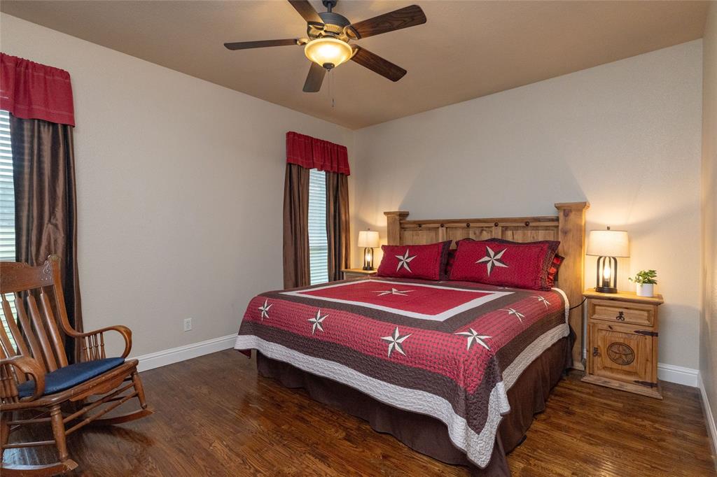 208 Ellis Creek Drive Weatherford, TX 76085 - Photo 29 of 40 a bedroom with a bed and a chandelier