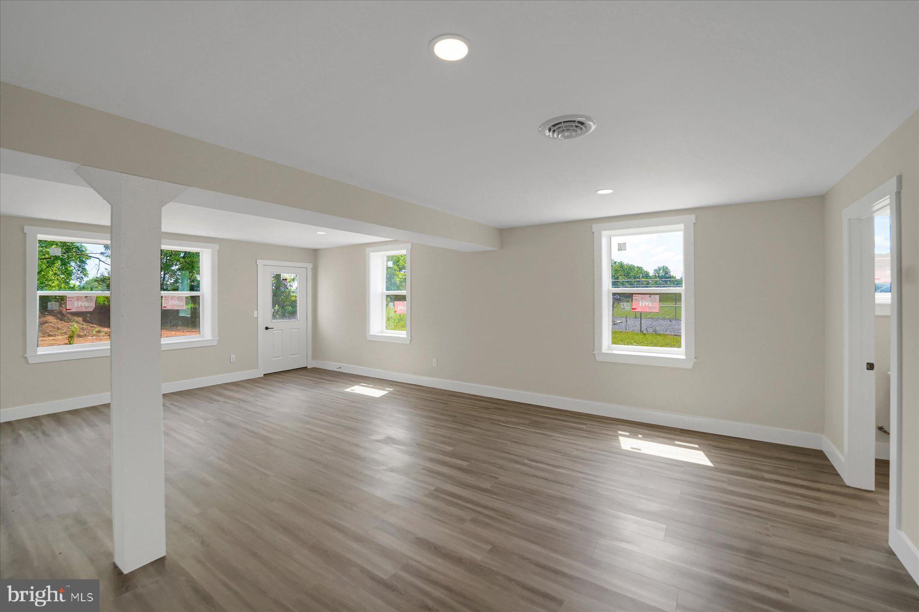 154 Saffron Boulevard Centre Hall, PA 16828 - Photo 50 of 57 an empty room with wooden floor and windows