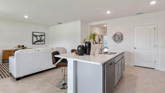 a kitchen with kitchen island a stove a sink a dining table and chairs