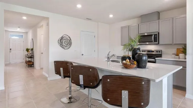 a living room with a sink and a refrigerator