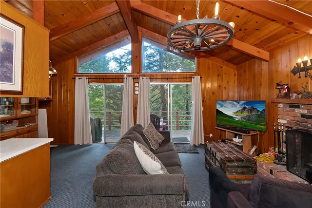 a living room with furniture a flat screen tv and a floor to ceiling window