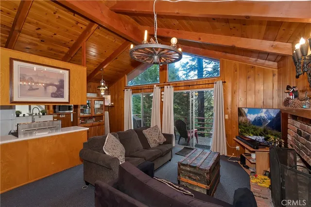 a living room with furniture a flat screen tv and a floor to ceiling window