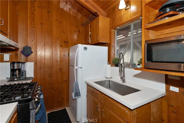 a kitchen with stainless steel appliances a sink a refrigerator and a stove