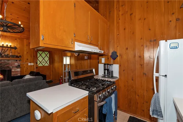 a kitchen with stainless steel appliances a stove a refrigerator and a dining table