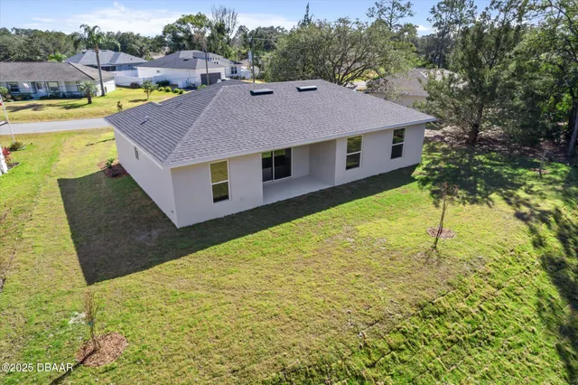 a aerial view of a house with a yard table and chairs