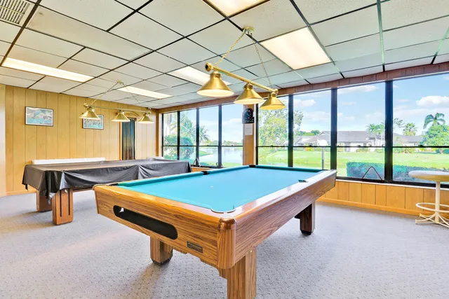 a room with pool table and windows