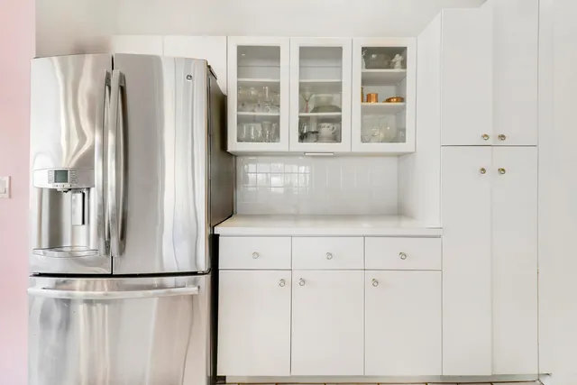 a kitchen with cabinets and refrigerator