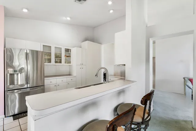 a close view of a sink a chair and a refrigerator