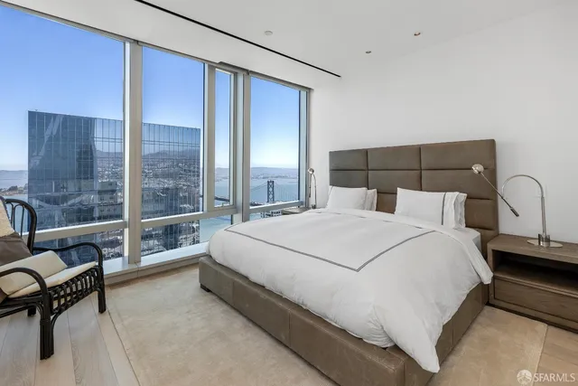 a large bed sitting in a bedroom next to a window