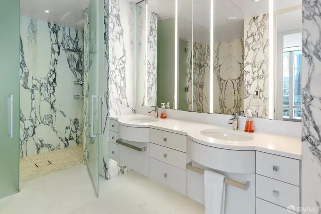 a bathroom with a double vanity sink mirror and shower