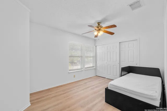 a bedroom with a bed and a chandelier fan