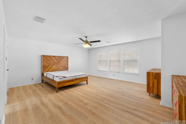 a view of a livingroom with wooden floor and a ceiling fan