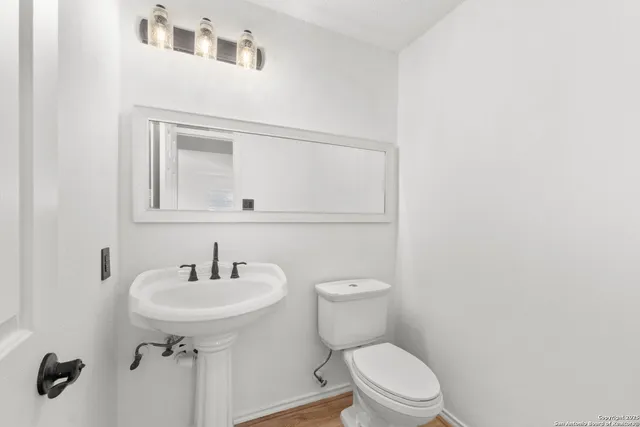 a bathroom with a sink toilet and mirror