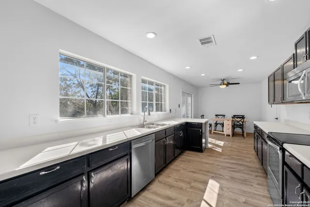 a large kitchen with stainless steel appliances granite countertop a lot of counter space and a sink
